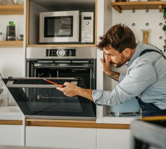 An Adam's technician repairing an oven in Lexington