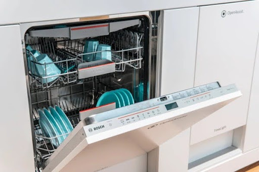 Dishwasher with an open door and turquoise blue plates - Call us for Bosch