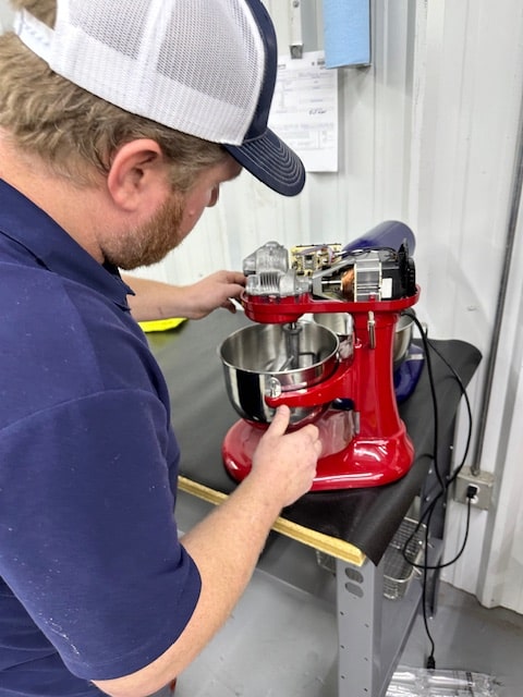 Photo of an Adam's technician working on a Kitchenaid mixer