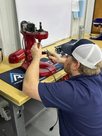 an Adams technician repairing a KitchenAide appliance - call now for service in 